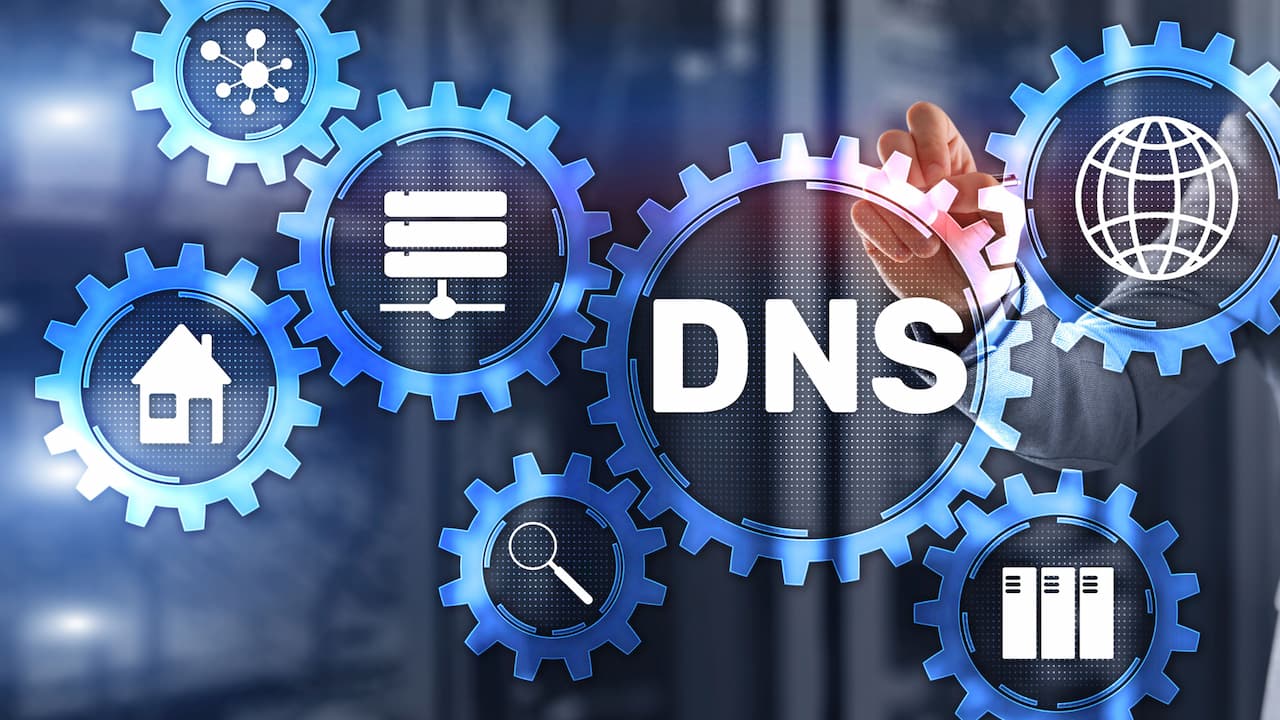 A person's hands are shown interacting with a central gear labeled 'DNS', surrounded by other gears each containing symbols such as a globe, servers, and a network icon, visually representing DNS as the pivotal element connecting various aspects of network infrastructure.